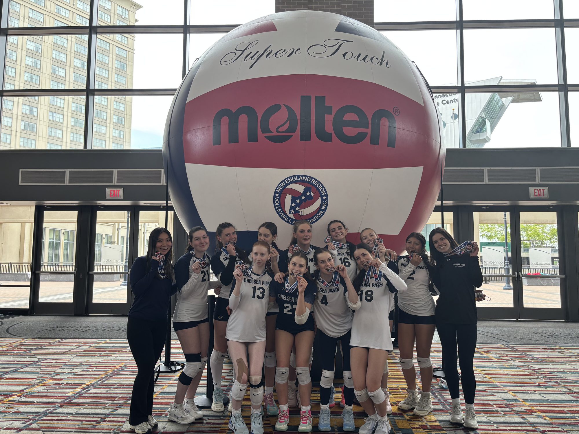 Team photo beneath the oversized Molten tournament ball